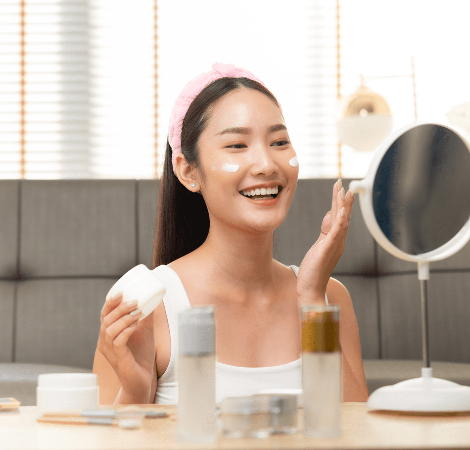 Woman applying skincare in front of mirror.